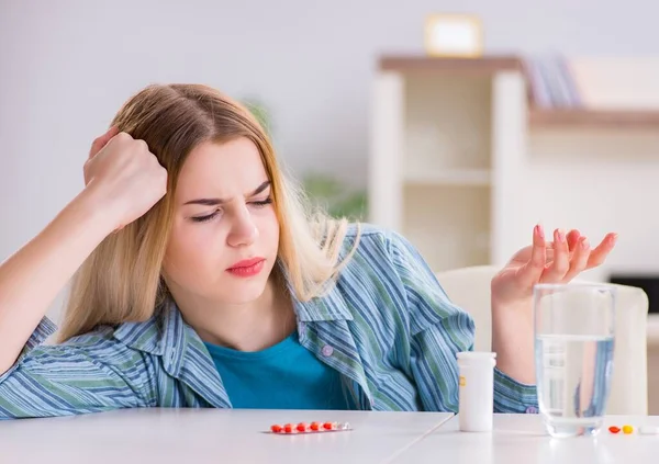 Mujer tomando pastillas para hacer frente al dolor — Foto de Stock