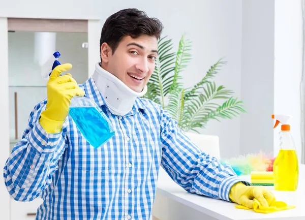 Uomo con collo unjury pulizia casa nel concetto di pulizia — Foto Stock