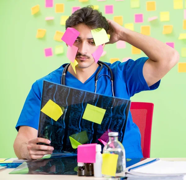 Giovane medico con molti promemoria e lavoro urgente — Foto Stock