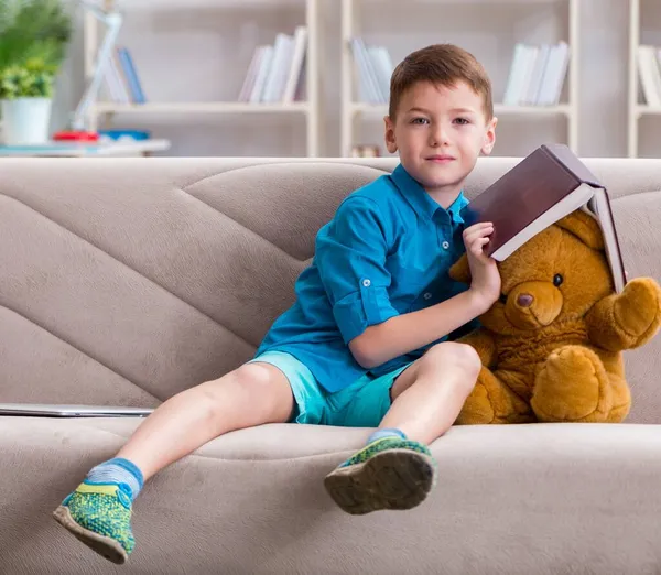 Маленький хлопчик читає книги вдома — стокове фото