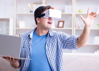 Evde sanal gerçeklik gözlükleriyle serbest çalışan bir öğrenci.
