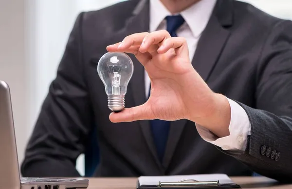 Businessman with light bulb in idea concept — Stock Photo, Image