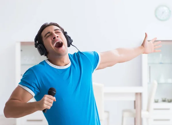Νεαρός όμορφος άντρας τραγουδάει καραόκε στο σπίτι — Φωτογραφία Αρχείου