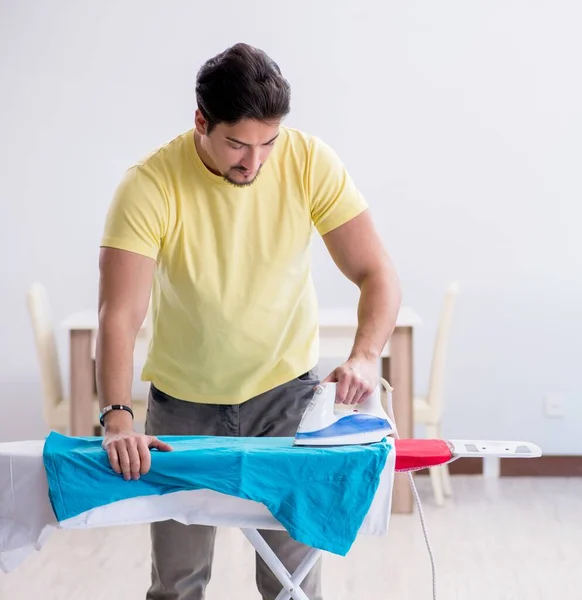 Schöner Mann Ehemann beim Bügeln von Kleidung zu Hause — Stockfoto