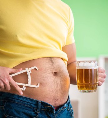 Diyet konseptinde bira tutan şişman obez adam.