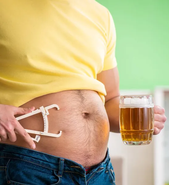 Hombre gordo obeso sosteniendo cerveza en concepto de dieta — Foto de Stock