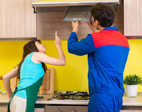 Frau diskutiert mit Bauunternehmer in Küche über Reparatur — Stockfoto
