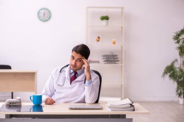 Klinikte çalışan genç erkek doktor.