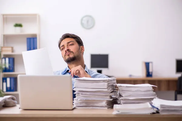 Jovem funcionário masculino e muito trabalho no escritório — Fotografia de Stock