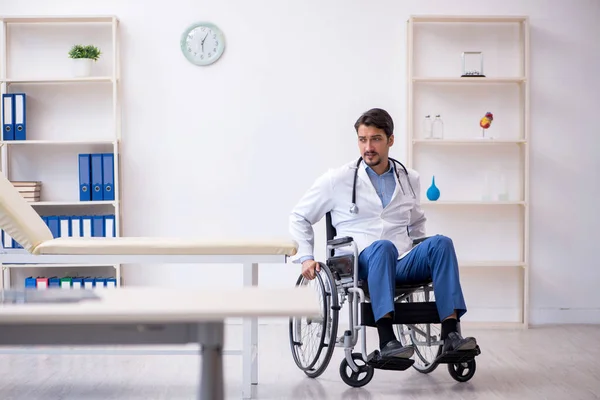 Young male doctor in wheel-chair working in the clinic — Stock Photo, Image