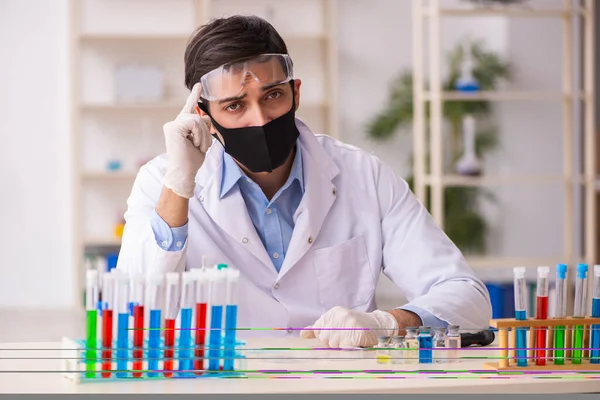 Jovem químico do sexo masculino que trabalha no laboratório durante a pandemia — Fotografia de Stock