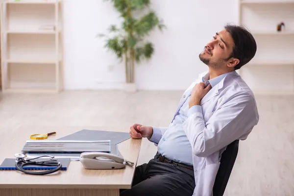 Ung manlig läkare som arbetar på kliniken — Stockfoto