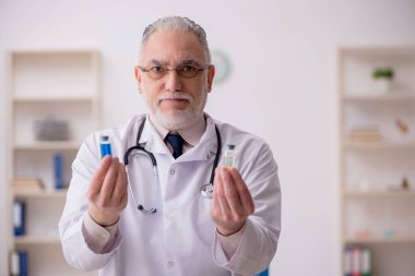 Aşı konseptinde yaşlı bir doktor.