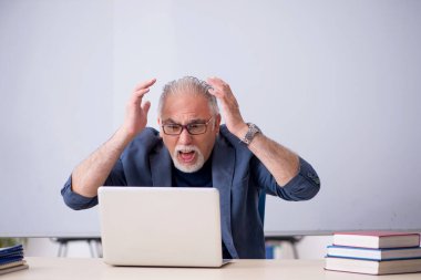 Tele-eğitim konseptinde yaşlı bir erkek öğretmen