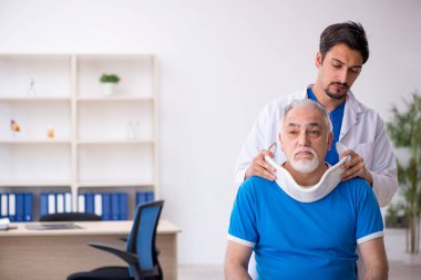 Yaşlı boyun yaralı erkek hasta genç erkek doktoru ziyaret ediyor.