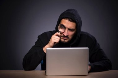 Gri arka planda genç erkek hacker