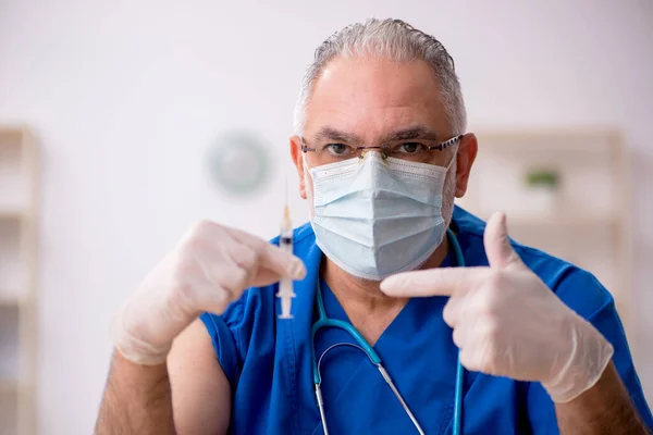 Velho médico do sexo masculino no conceito de vacinação — Fotografia de Stock