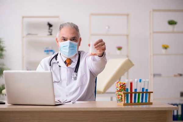 Stary lekarz pracujący w klinice podczas pandemii — Zdjęcie stockowe