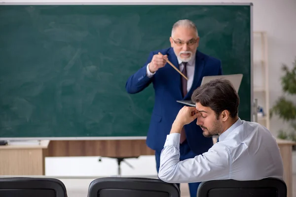 Viejo profesor masculino y joven estudiante masculino delante del tablero verde —  Fotos de Stock