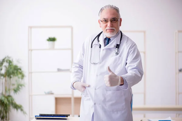 Viejo médico que trabaja en la clínica —  Fotos de Stock