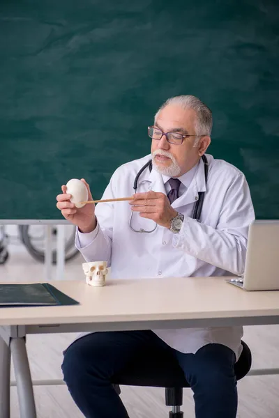 Old male doctor teacher in front of blackboard — Stock Photo, Image