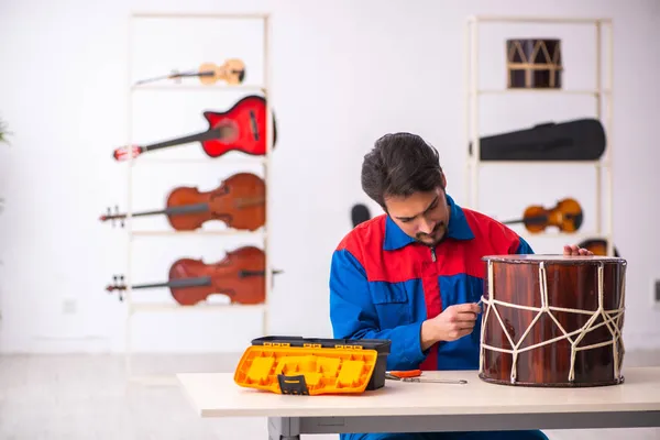 Fiatal férfi szerelő hangszereket javít a munkahelyen — Stock Fotó