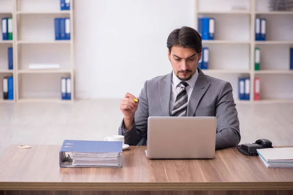 Young attractive male employee sitting at workplace — Stock Photo, Image