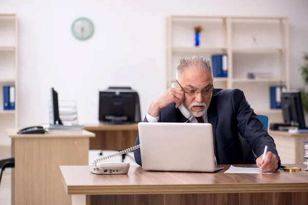 Ancien employé masculin travaillant dans le bureau — Photo