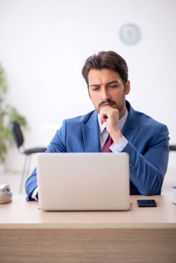 İş yerinde çalışan genç bir erkek.