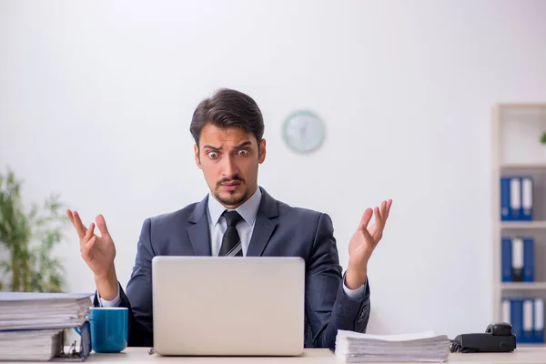 Junge männliche Mitarbeiter sitzen am Arbeitsplatz — Stockfoto