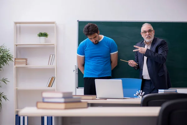Old male teacher and young male student in front of blackboard — Stock Photo, Image