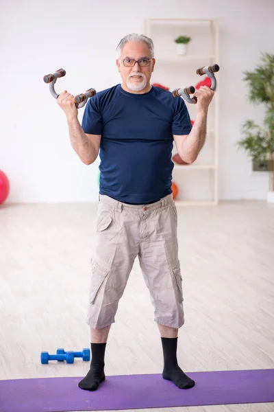 Yaşlı adam içeride spor egzersizleri yapıyor. — Stok fotoğraf