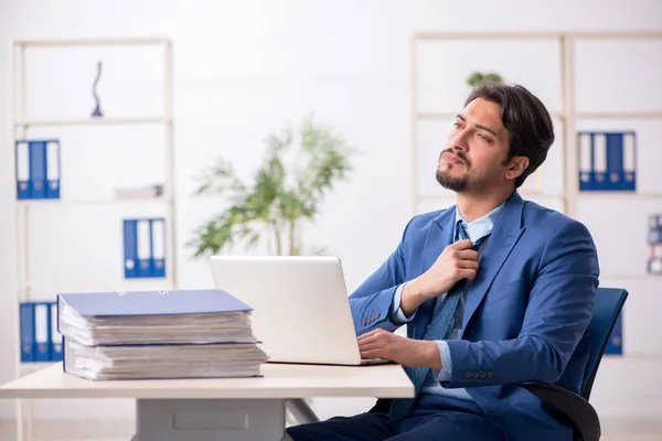 Junge männliche Mitarbeiter und zu viel Arbeit im Büro — Stockfoto