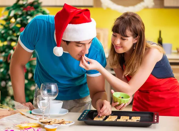 Молодая пара празднует Рождество на кухне — стоковое фото