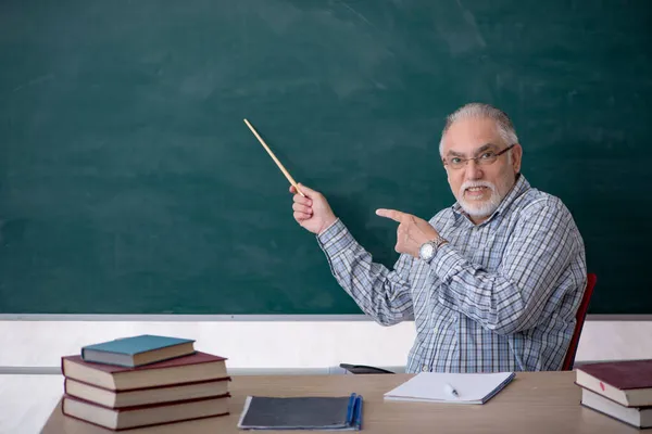 Старий вчитель чоловічої статі в класі — стокове фото