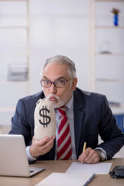 Old male employee in remuneration concept at workplace — Stock Photo, Image