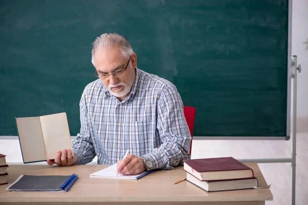 Sınıftaki yaşlı erkek öğretmen.