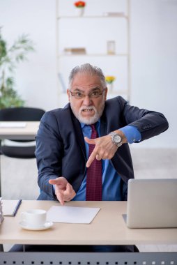 Ofiste çalışan yaşlı bir erkek.