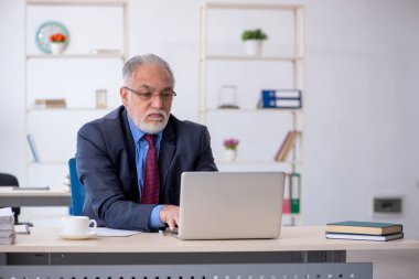 Ofiste çalışan yaşlı bir erkek.