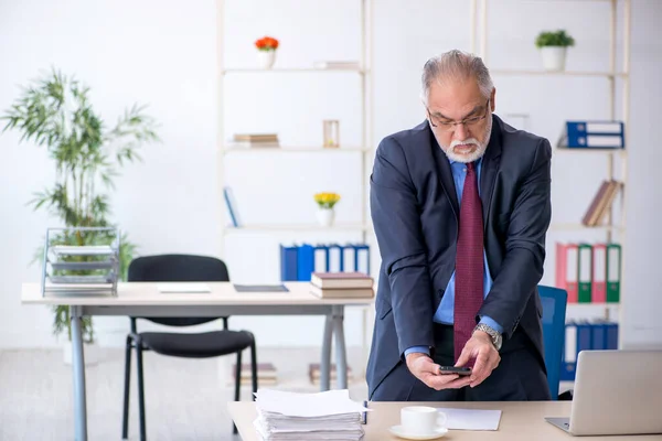 Velho empregado do sexo masculino que trabalha no escritório — Fotografia de Stock