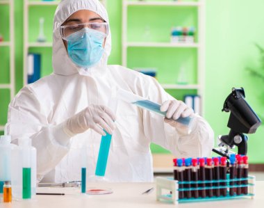 Laboratuvarda yeni bir deney üzerinde çalışan kimyager.