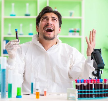 Laboratuvarda yeni bir deney üzerinde çalışan kimyager.