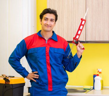 Mutfakta çalışan bir tamirci.