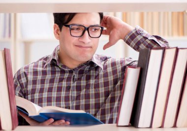 Üniversite kütüphanesinde kitap arayan genç bir öğrenci.