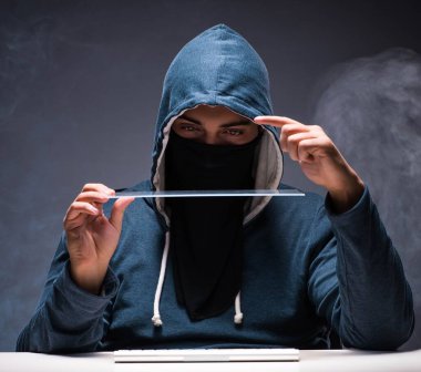 Bilgisayar korsanı karanlık odada çalışıyor.