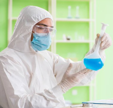 Laboratuvarda yeni bir deney üzerinde çalışan kimyager.