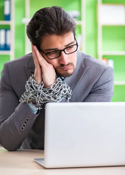 Empregado acorrentado à sua mesa devido à carga de trabalho — Fotografia de Stock