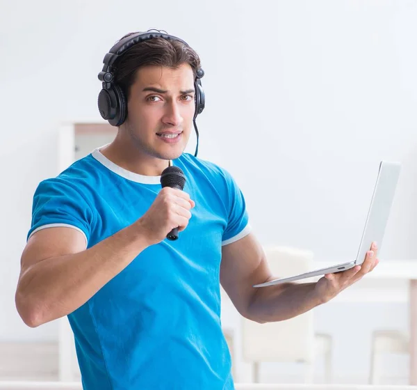 Jovem homem bonito cantando karaoke em casa — Fotografia de Stock