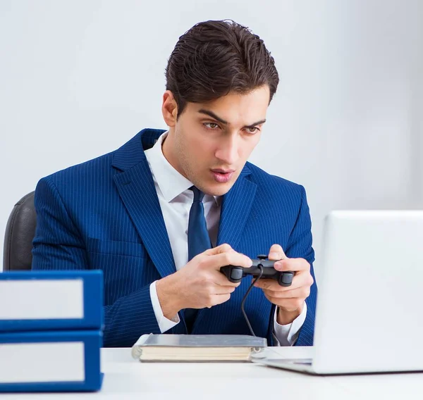 Jovem empresário bonito jogando jogos de computador no escritório de trabalho — Fotografia de Stock