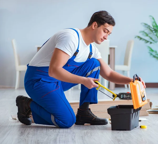 Reparador que pone suelo laminado en casa — Foto de Stock
